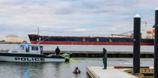 Police boat near dock with divers in water