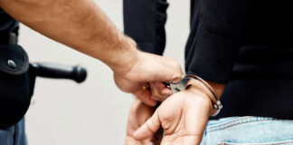 Person in handcuffs being arrested by police officer