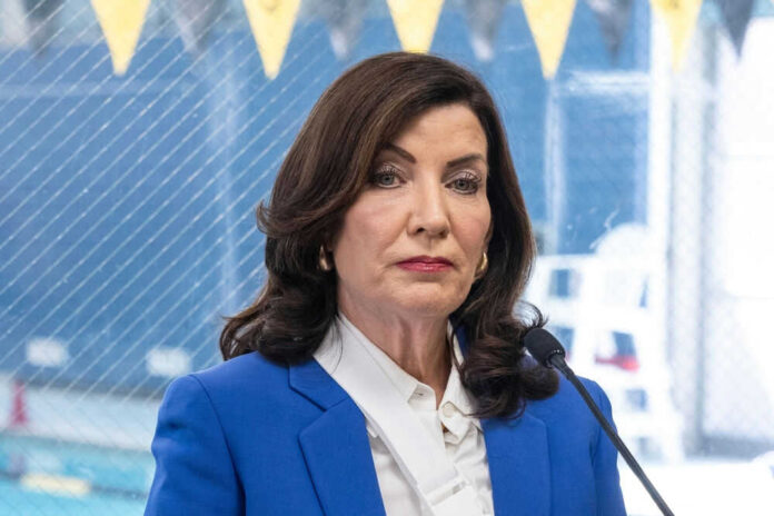 2409036021 Woman in blue blazer speaking into microphone