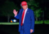 Man in suit wearing red hat outside at night