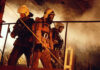 Firefighters in protective gear navigating through smoke