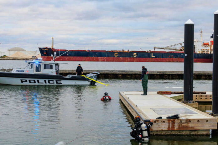 Police boat near dock with divers in water