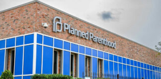 Brick building with blue windows and logo signage