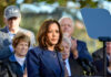 Woman speaking at podium with audience behind her
