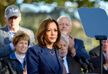 Woman speaking at podium with audience behind her