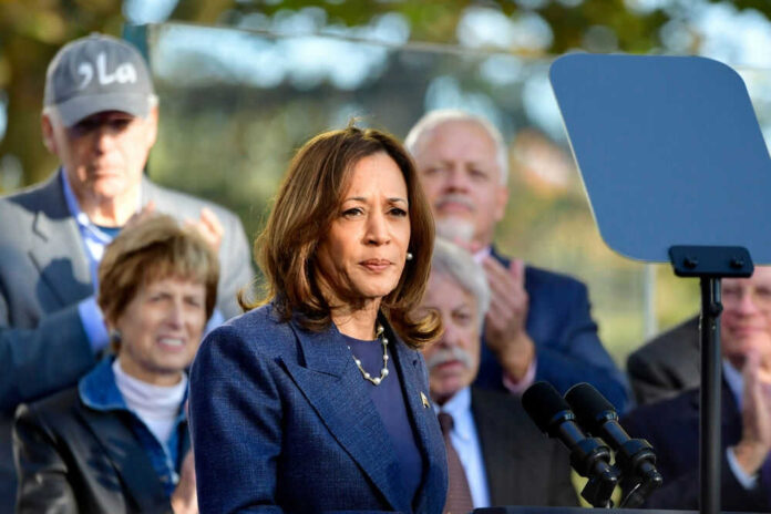 Woman speaking at podium with audience behind her