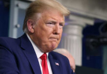Man in suit and red tie looks serious
