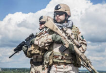 Two soldiers in desert camouflage holding rifles