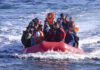 A group of people in a red inflatable boat on the ocean