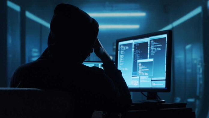 Person in a hoodie using multiple computer screens