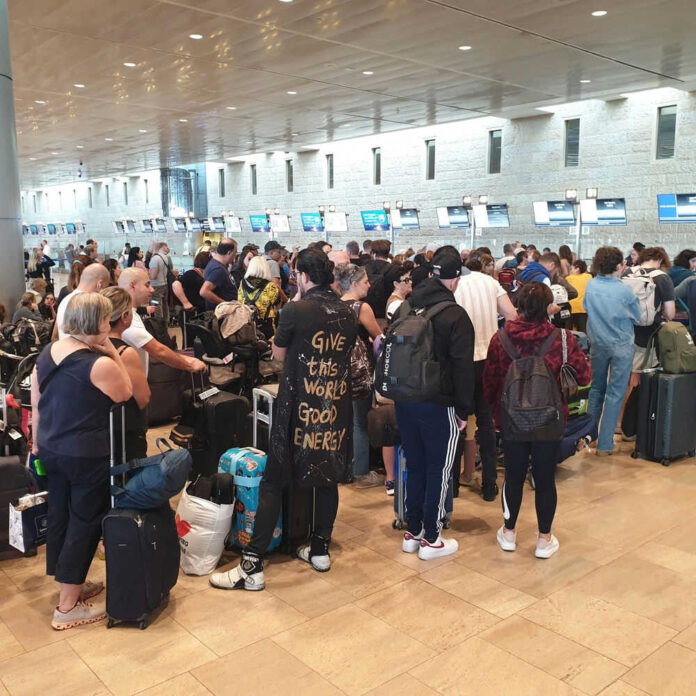 Crowded airport checkin area with many passengers waiting