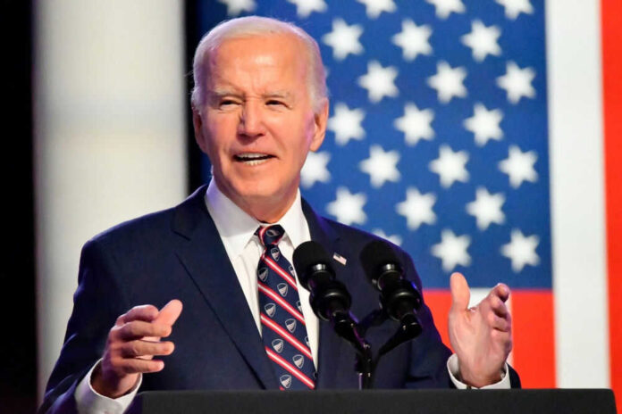 Man speaking at podium with American flag backdrop