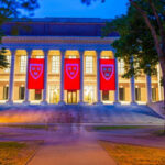 Illuminated library building with red banners at night
