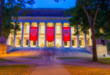 Illuminated library building with red banners at night