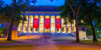Illuminated library building with red banners at night