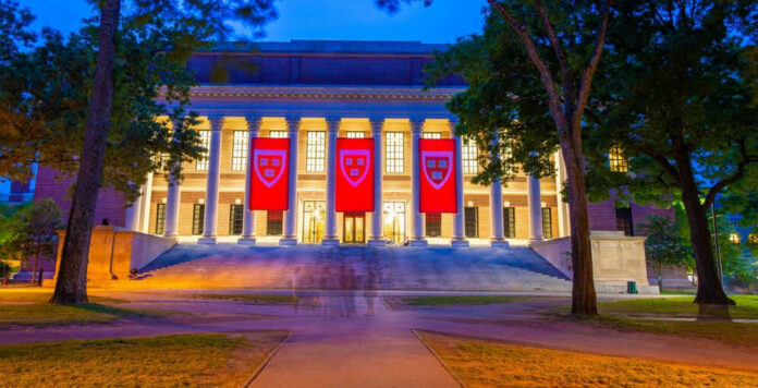Illuminated library building with red banners at night